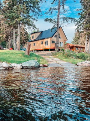 a beautiful scenery of a river flowing besides a house