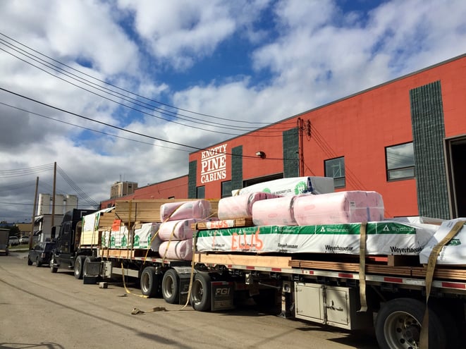 truck carrying load outside knotty pine cabins factory